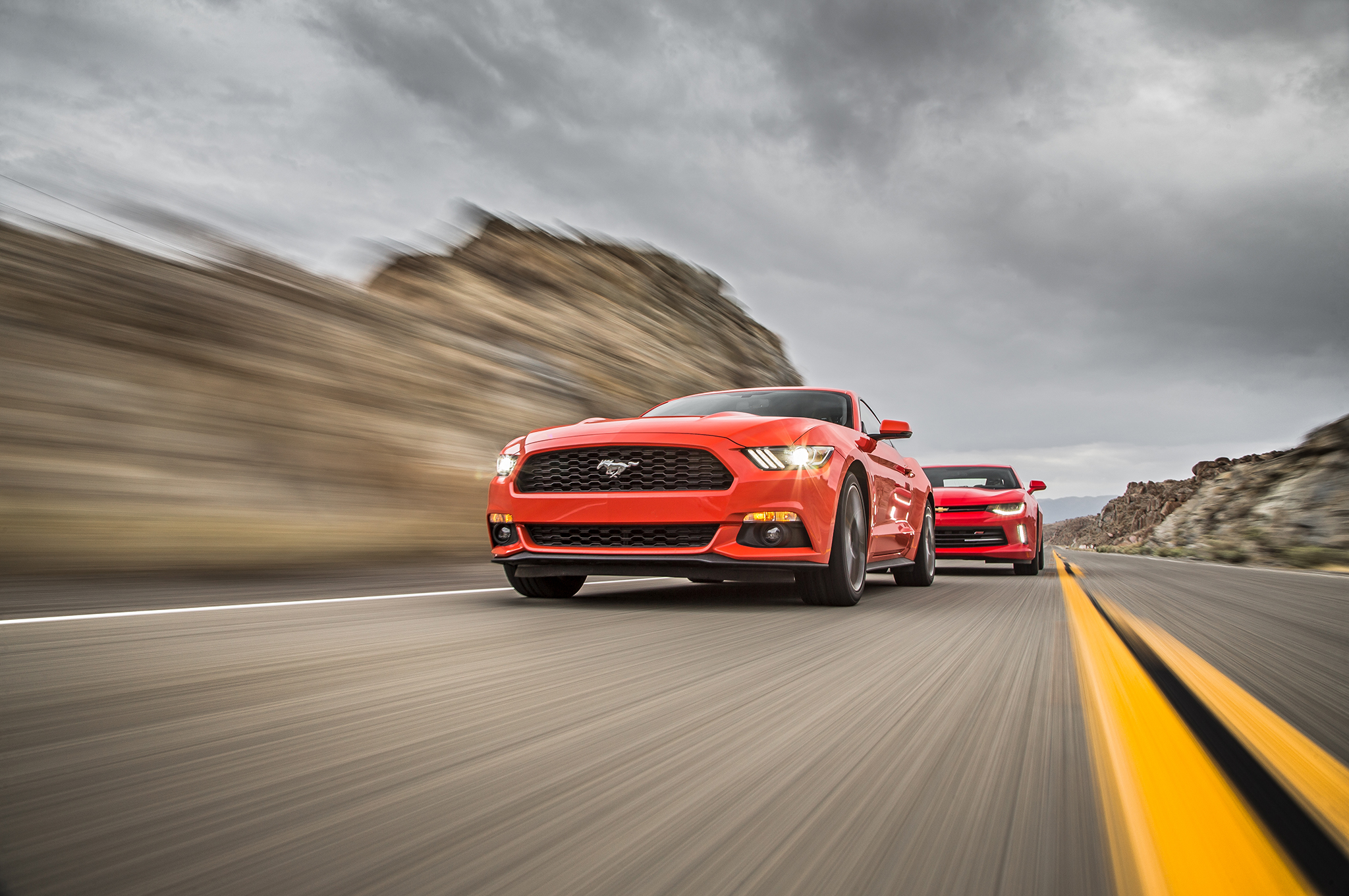 2016 Chevrolet Camaro RS 2016 Ford Mustang EcoBoost front three quarter in motion