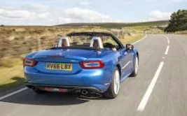 Fiat 124 Spider driving, rear, roof down 